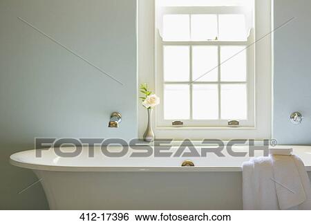 Stock Photograph - Soaking tub below window in luxury bathroom. Fotosearch