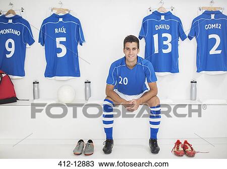 Stock Image - Soccer player sitting in locker room. Fotosearch