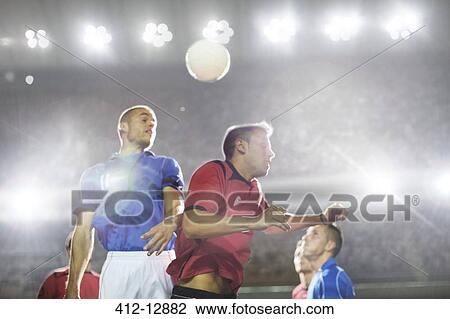 Soccer players jumping for ball on field View Large Photo Image Stock Image - Soccer players jumping for ball on field. Fotosearch