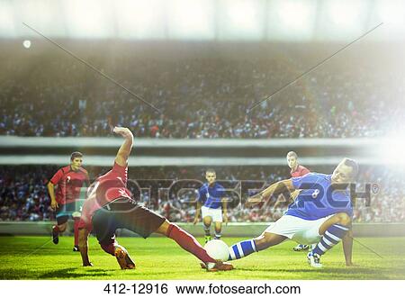 Soccer players kicking at ball on field View Large Photo Image Stock Photograph - Soccer players kicking at ball on field. Fotosearch