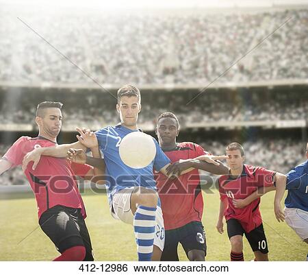 Soccer players reaching for ball on field View Large Photo Image Stock Photograph - Soccer players reaching for ball on field. Fotosearch