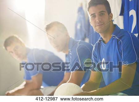 Stock Photo - Soccer players sitting in locker room. Fotosearch