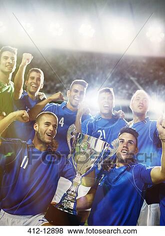 Soccer team celebrating with trophy in stadium View Large Photo Image Stock Photo - Soccer team celebrating with trophy in stadium. Fotosearch