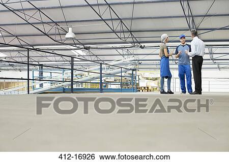 Stock Photograph - Supervisor and workers talking in food processing plant. Fotosearch