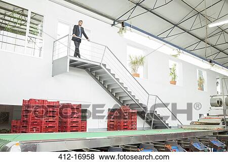 Supervisor standing on platform in food processing plant View Large Photo Image Stock Photo - Supervisor standing on platform in food processing plant. Fotosearch