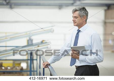 Stock Image - Supervisor with digital tablet in food processing plant. Fotosearch
