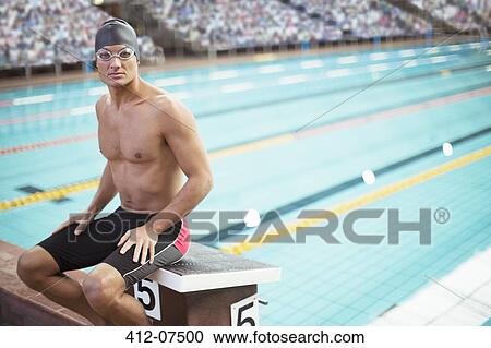 Swimmer sitting on starting block at poolside View Large Photo Image Stock Image - Swimmer sitting on starting block at poolside. Fotosearch