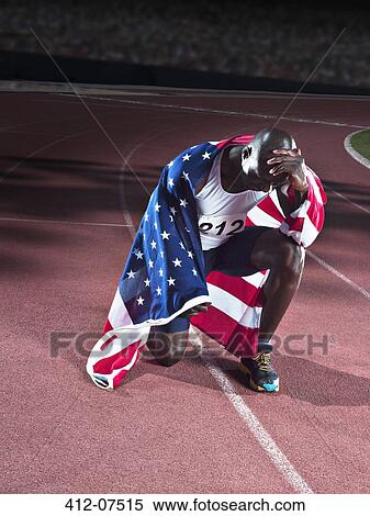 Stock Photography - Track and field athlete wrapped in American flag on track. Fotosearch
