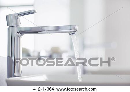 Water pouring from modern faucet in bathroom View Large Photo Image Picture - Water pouring from modern faucet in bathroom. Fotosearch