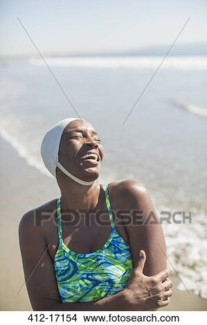 Woman in bathing suit and cap laughing on beach View Large Photo Image Picture - Woman in bathing suit and cap laughing on beach. Fotosearch