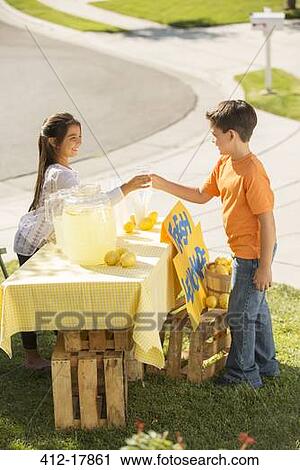 Stock Image - Boy buying lemonade at lemonade stand. Fotosearch
