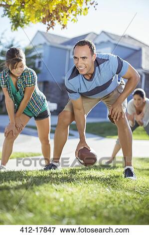 Family playing football in grass View Large Photo Image Stock Photo - Family playing football in grass. Fotosearch