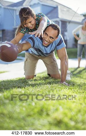 Father and daughter playing football in grass View Large Photo Image Stock Image - Father and daughter playing football in grass. Fotosearch