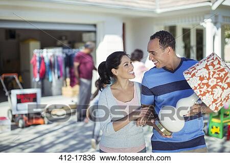 Stock Photograph - Happy couple buying lamp at yard sale. Fotosearch