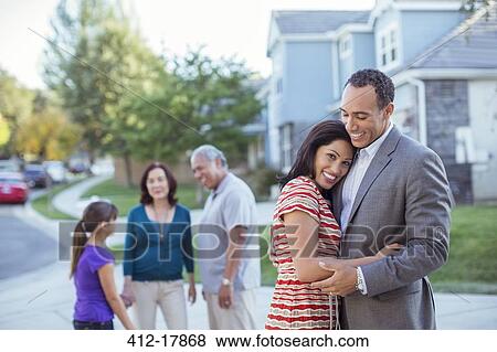 Stock Photo - Happy couple hugging in driveway. Fotosearch