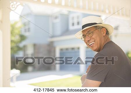 Stock Photography - Laughing man on sunny porch. Fotosearch
