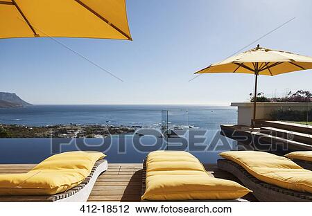 Lounge chairs overlooking infinity pool and ocean View Large Photo Image Stock Image - Lounge chairs overlooking infinity pool and ocean. Fotosearch