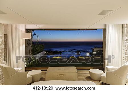 Modern bedroom overlooking ocean at night View Large Photo Image Stock Image - Modern bedroom overlooking ocean at night. Fotosearch