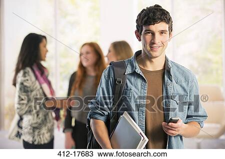 Stock Image - Portrait of college student text messaging with cell phone. Fotosearch