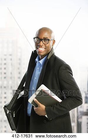 Stock Image - Portrait of confident businessman in urban window. Fotosearch