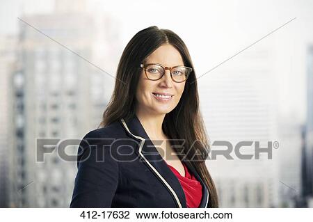 Stock Image - Portrait of confident businesswoman in urban window. Fotosearch