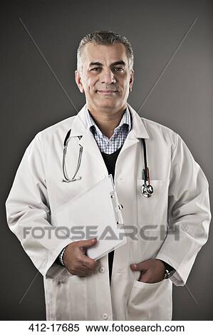 Portrait of confident doctor with clipboard View Large Photo Image Stock Photography - Portrait of confident doctor with clipboard. Fotosearch