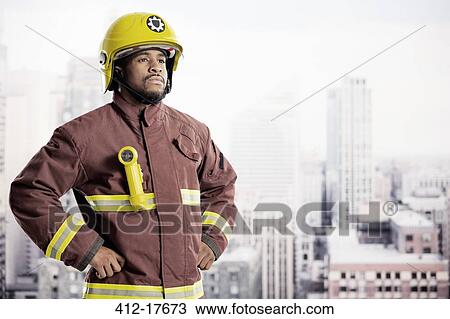 Stock Image - Portrait of confident fireman in urban window. Fotosearch