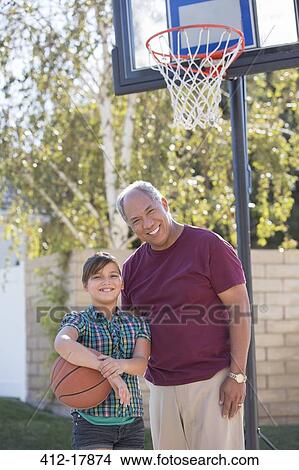Picture - Portrait of grandfather and granddaughter playing basketball. Fotosearch