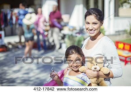 Stock Image - Portrait of mother and daughter shopping at yard sale. Fotosearch