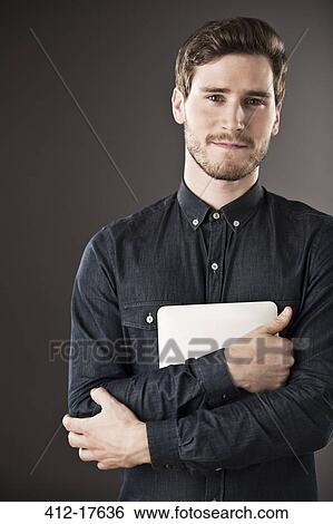 Portrait of serious businessman holding digital tablet View Large Photo Image Stock Photograph - Portrait of serious businessman holding digital tablet. Fotosearch