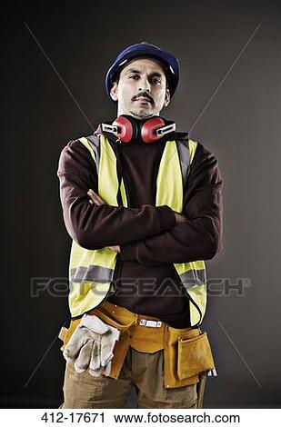 Stock Image - Portrait of serious worker in reflective clothing. Fotosearch