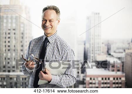 Portrait of smiling businessman in urban window View Large Photo Image Picture - Portrait of smiling businessman in urban window. Fotosearch