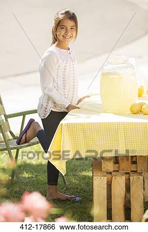 Stock Photograph - Portrait of smiling girl working lemonade stand. Fotosearch