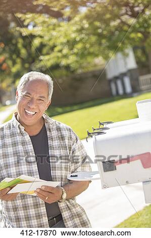 Portrait of smiling man retrieving mail from mailbox View Large Photo Image Stock Image - Portrait of smiling man retrieving mail from mailbox. Fotosearch