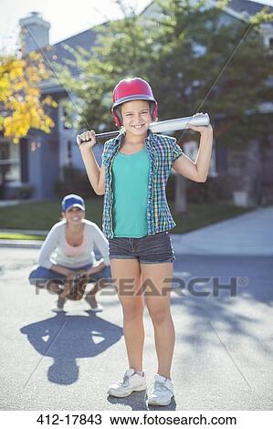 Portrait of smiling mother and daughter playing baseball View Large Photo Image Stock Image - Portrait of smiling mother and daughter playing baseball. Fotosearch