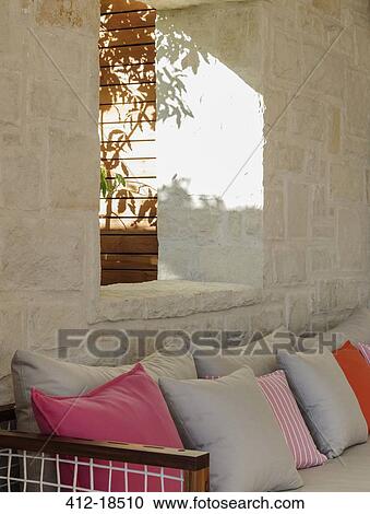 Stone wall behind patio bench with cushions View Large Photo Image Stock Image - Stone wall behind patio bench with cushions. Fotosearch