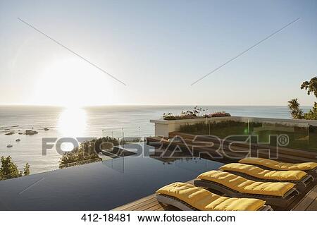 View of sunset over ocean from luxury patio View Large Photo Image Stock Image - View of sunset over ocean from luxury patio. Fotosearch