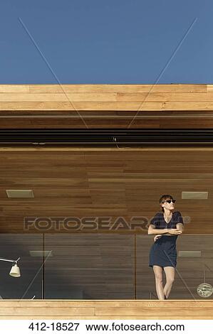 Woman standing on luxury balcony View Large Photo Image Stock Photo - Woman standing on luxury balcony. Fotosearch