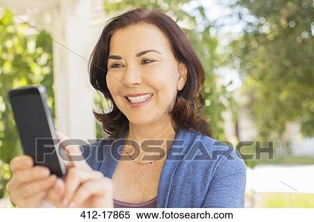Stock Photography - Woman text messaging with cell phone. Fotosearch
