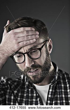 Stock Photography - Worried man with head in hands. Fotosearch