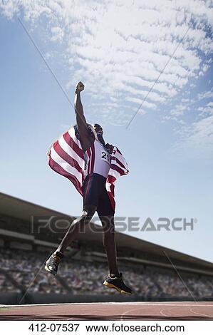 American track and field athlete cheering on track with American flag View Large Photo Image Stock Photo - American track and field athlete cheering on track with American flag. Fotosearch