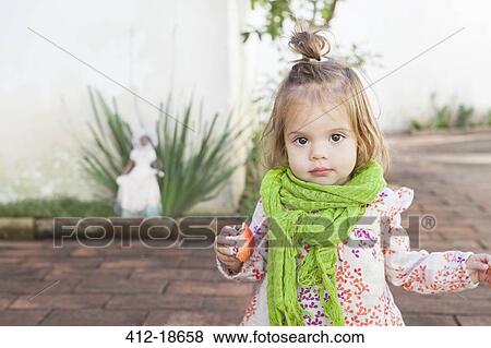 Baby girl eating fruit outdoors View Large Photo Image Stock Photo - Baby girl eating fruit outdoors. Fotosearch