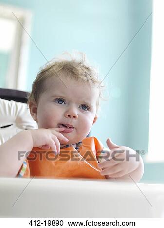 Baby girl eating in high chair View Large Photo Image Stock Image - Baby girl eating in high chair. Fotosearch