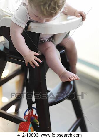 Baby girl in high chair reaching for toy View Large Photo Image Stock Image - Baby girl in high chair reaching for toy . Fotosearch