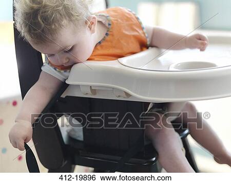 Baby girl playing in high chair View Large Photo Image Stock Photograph - Baby girl playing in high chair. Fotosearch