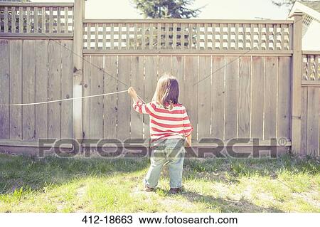 Baby girl playing with string in backyard View Large Photo Image Stock Image - Baby girl playing with string in backyard. Fotosearch