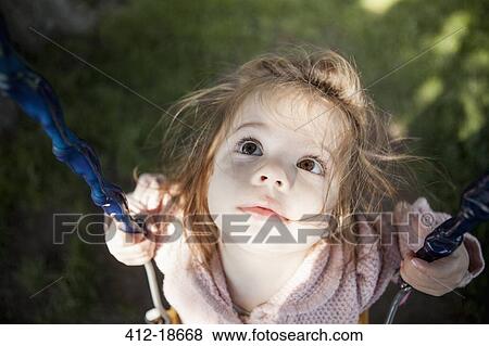 Baby girl sitting on swing outdoors View Large Photo Image Stock Photo - Baby girl sitting on swing outdoors. Fotosearch
