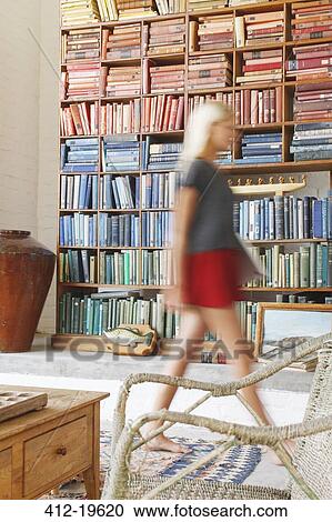 Blurred view of woman walking by bookcase View Large Photo Image Stock Image - Blurred view of woman walking by bookcase. Fotosearch