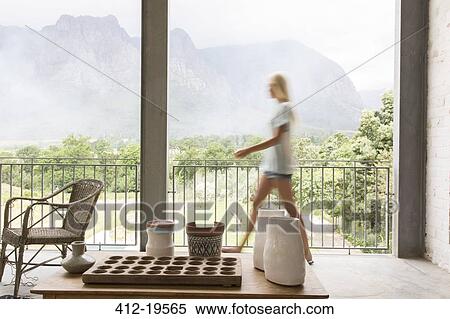 Stock Photography - Blurred view of woman walking on patio. Fotosearch