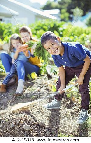 Boy turning over dirt in garden View Large Photo Image Stock Photo - Boy turning over dirt in garden. Fotosearch